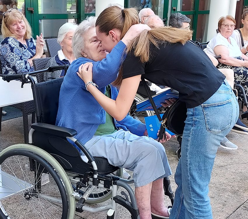 une jeune fille embrassant une personne âgée